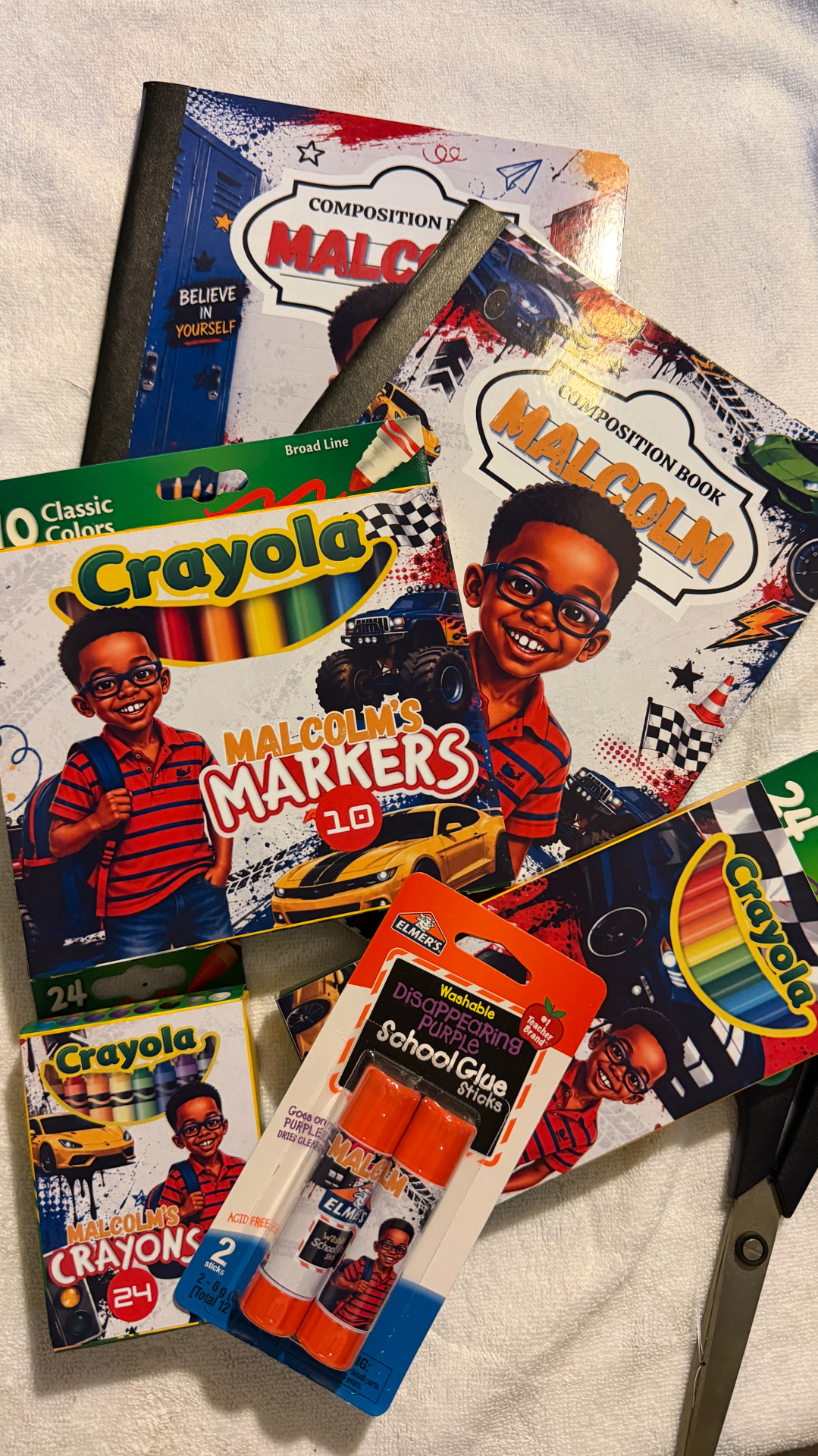 Personalized school supplies featuring custom notebooks, markers, crayons and glue